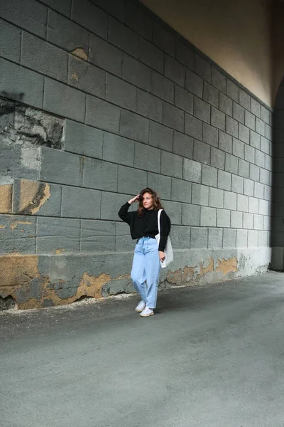 Arka planda sıradan kıyafetler giyen genç bir kadın.