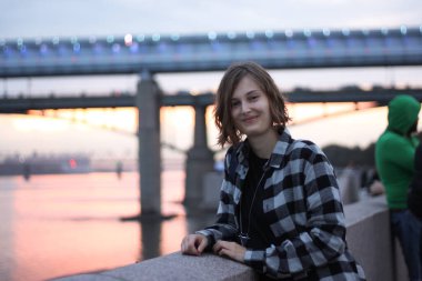 Hücrenin önünde gülümseyen genç bir kadının portresi