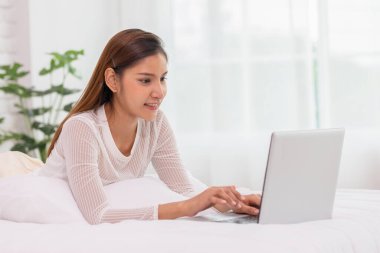 İnternetten alışveriş yapmak için bilgisayar kullanan Asyalı genç bir kadın.