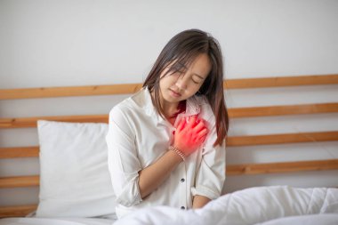 Kadın sabah uyandıktan sonra kalp krizi geçirir. Sağlık sigortası konsepti.