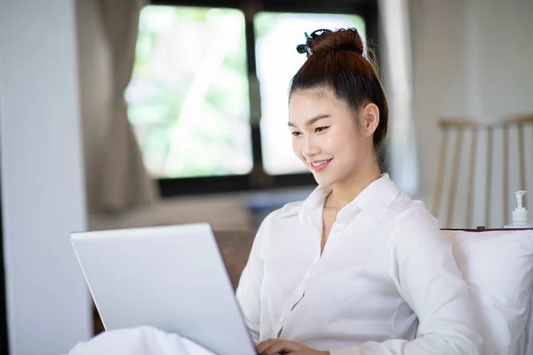美しい魅力的なアジアの若い女性がベッドの上に横たわって 休日の寝室でソーシャルメディアやショッピングをオンラインでリラックスするためにコンピュータのラップトップを使用して 寝室のコンセプトのライフスタイル — ストック写真