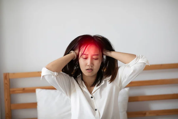 アジアの若い女性は 朝目が覚めた後 片頭痛や頭痛を持っています ヘルスケアコンセプト ストック画像