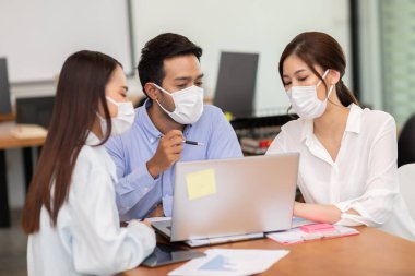 İş adamı ve kadın yüz maskesi takıyor ve tartışma ve beyin yıkama için birlikte çalışıyor. Toplumsal uzaklık virüsü salgınıyla fikir ya da pazarlama çözümü elde etmek için.