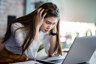 İş dünyasından Asyalı kadınların migreni vardır. Baş ağrısı ve stres, iş yerinde sorun, ofis sendromu konsepti, seçici odaklanma sorunu yaşar.