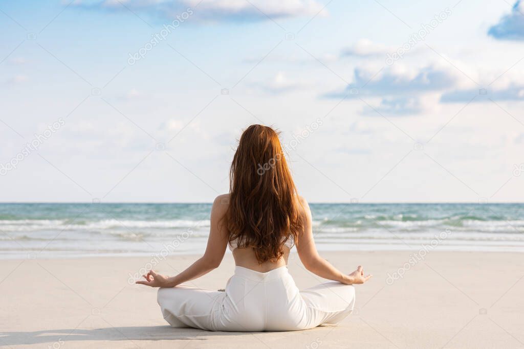 Back of views woman practice yoga lotus pose to meditation with summer vacation on the beach feeling so happiness and cheerful,Travel in tropical beach in Thailand,vacations and relaxation Concept