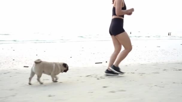 Silna Kobieta Biegająca Piasku Plaży Psią Rasą Mopsa Relaksuje Się — Wideo stockowe