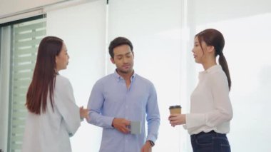 Neşeli genç iş adamı kahve molası verip kahve fincanı tutarak ofiste rahatlayın. 