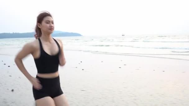 ビーチで砂の上でランニングやトレーニングを強力な女性アスリートランナーワークアウトライフスタイルの休暇コンセプト — ストック動画