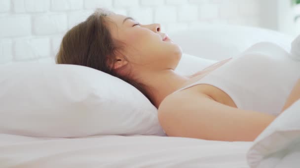 파자마를 아름다운 아시아 여성은 미소짓고 아침에 침실에서 잠자리에서 — 비디오
