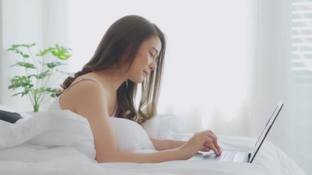 Όμορφη Ελκυστική Ασιατική Νεαρή Γυναίκα Ξαπλωμένη Στο Κρεβάτι Και Χρησιμοποιώντας — Αρχείο Βίντεο
