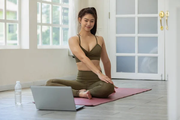 アスリートアジアの女性は 自宅で瞑想快適でリラックスしたヨガのオンラインコースを練習ノートパソコンを探しています 自宅でヨガの練習コンセプト Covid 19パンデミックによる自己分離 — ストック写真