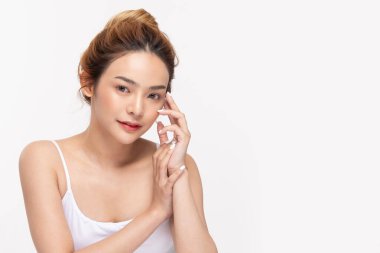 Güzel Asyalı genç bir kadın yumuşak yanaklı gülüşüne dokunuyor taze tenli mutlu ve neşeli, olumlu duygusal, beyaz arka planda soyutlanmış, Güzellik Kozmetik ve Yüz Bakımı Konsepti