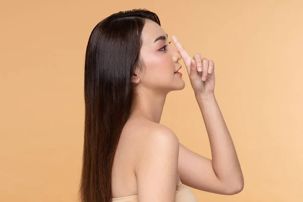 Beautiful Asian woman touching nose smile with clean and fresh skin Happiness and cheerful with positive emotional on Beige,Plastic Surgery nose,Beauty Cosmetics and spa facial treatment Concept