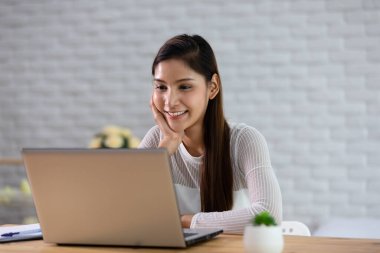 Bilgisayar laptopuyla çalışan güzel, Çekici Asyalı bir Hintli kadın. Evde işe başlamak için fikir ve gereksinim edinmeyi düşünüyor. Mutluluk, Girişim Konsepti.