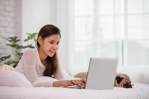 Mujer Escribiendo Trabajando Ordenador Portátil Con Perro Pug Raza Acostado — Foto de Stock