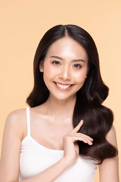 美丽的亚洲年轻女子 动人的秀发 清新的肌肤 快乐而快乐 积极向上的情绪 与米色背景 美容美发及面部护理理念相分离 — 图库照片