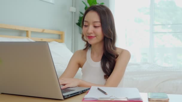 自宅でオンラインショッピングのためのラップトップで作業し 注文を配達するために顧客と話す若いアジアの女性のビジネススタートアップ — ストック動画