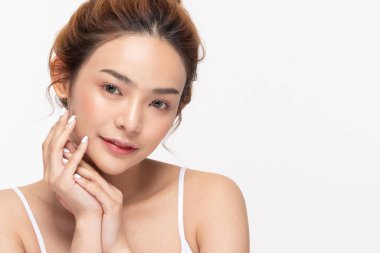 Güzel Asyalı genç bir kadın yumuşak yanaklı gülüşüne dokunuyor taze tenli mutlu ve neşeli, olumlu duygusal, beyaz arka planda soyutlanmış, Güzellik Kozmetik ve Yüz Bakımı Konsepti