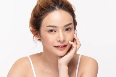 Güzel Asyalı genç bir kadın yumuşak yanaklı gülüşüne dokunuyor taze tenli mutlu ve neşeli, olumlu duygusal, beyaz arka planda soyutlanmış, Güzellik Kozmetik ve Yüz Bakımı Konsepti