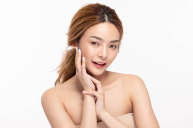 Güzel Asyalı genç bir kadın yumuşak yanaklı gülüşüne dokunuyor taze tenli mutlu ve neşeli, olumlu duygusal, beyaz arka planda soyutlanmış, Güzellik Kozmetik ve Yüz Bakımı Konsepti