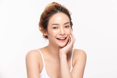 Güzel Asyalı genç bir kadın yumuşak yanaklı gülüşüne dokunuyor taze tenli mutlu ve neşeli, olumlu duygusal, beyaz arka planda soyutlanmış, Güzellik Kozmetik ve Yüz Bakımı Konsepti