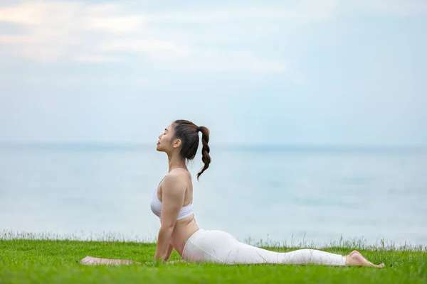 Athletic Asian Young Woman Practice Cobra Pose Green Grass Beach — Stock Photo, Image