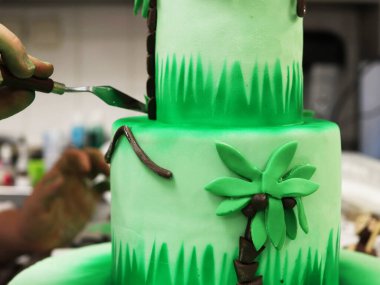 Aşçı pastanın ortasındaki dekorasyonu temizler ve hizalar..