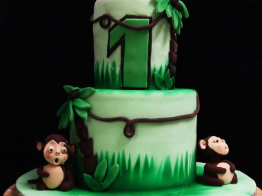 Maymunlu, palmiye ağaçlı, hindistan cevizli ve sarmaşıklı iki kek.