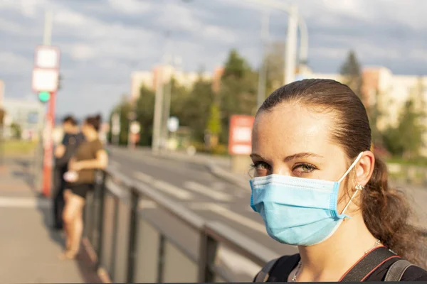 Tramvay durağında ağzı maskeli bir kızın fotoğrafı çekildi..