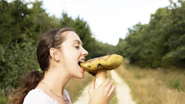 Menina Morde Cogumelo Gigante Floresta — Fotografia de Stock