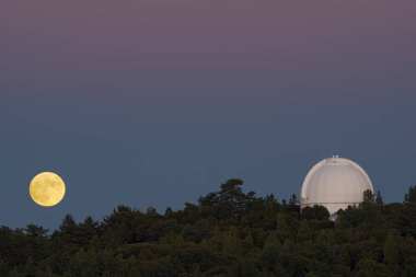Wilson Mt'inde bir alacakaranlık gökyüzüne ve gözlemevi kubbeye karşı neredeyse tam yükseleni gösteren güzel görüntü.