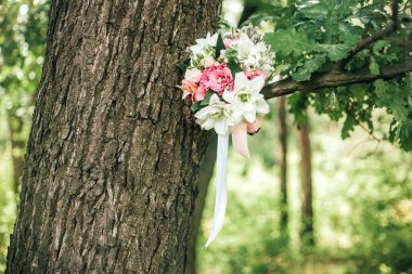 Gelinin ağaçtaki beyaz zambaklardan yapılmış güzel bir buketi. Yakın plan. Tatil konsepti: Düğün, 8 Mart, Uluslararası Kadınlar Günü. Tebrik kartı. Metin için yer