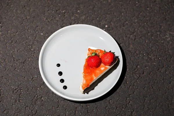 Close up of strawberry cheese cake slice on a plate