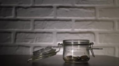 4 bin. Erkek eli yakın, bozuk para atıyor, kumbaraya avro atıyor. Para depolamak için kullanışlı cam kavanoz ve mandalında güzel bir kapak..