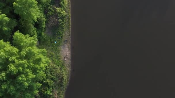 4K. Shooting with the drone, top view. Two fishermen on the Bank of the pond are preparing for fishing by patiently and repeatedly throwing food far into the pond. — Stock Footage Shooting Drone Top View Two Fishermen Bank Pond Preparing Fishing Video Clip