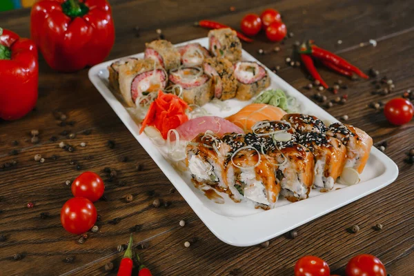 Rollen Und Sushi Auf Einem Teller Umgeben Von Gemüse Und lizenzfreie Stockbilder