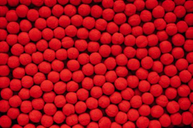 Kırmızı ponponlar, dikiş aksesuarları, kıyafet dekorasyonları. Mesaj için yer var.