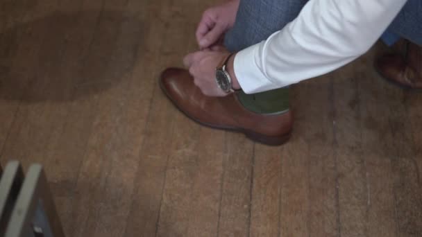 Homem Calças Azuis Amarra Atacadores Sapatos Castanhos Chão Madeira — Vídeo de Stock