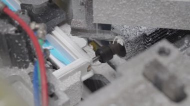4 bin. Plastik bir pencerenin kaynaklarını kesme ve temizleme makinesi. PVC pencere profilinde drenaj delikleri ve impost değirmenleri.
