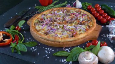 4 bin. Taze, lezzetli İtalyan pizzası ve içindekiler. Arka planda, yemek maşasıyla bir el lezzetli bir pizza alır..