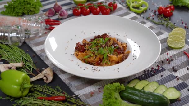 おいしいです トマトソースとおいしい古典的なイタリアのパスタスパゲティ 白プレートとテーブルの上にパルメザンチーズとバジル 上からの眺め — ストック動画