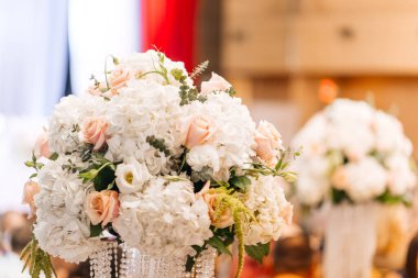 Masada güller olan bir buket beyaz ortanca.