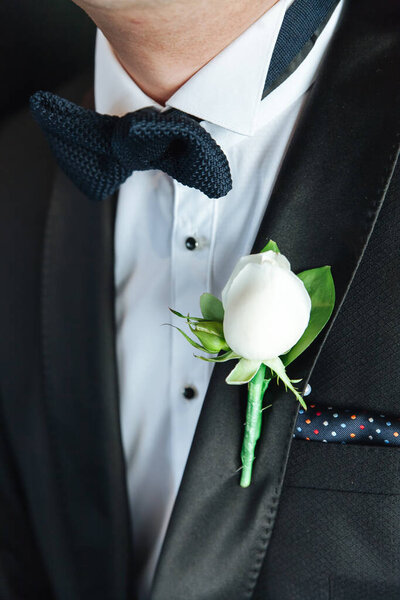 White rose boutonniere on the groom's jacket