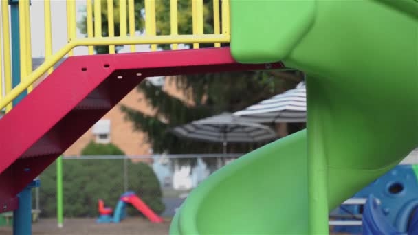 幼儿园院子里有秋千和游乐区的游乐场 用铁栅栏围起来保护孩子们的安全 — 图库视频影像