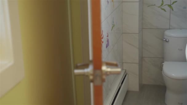 トイレはタイル張りの壁と床でミニマルなインテリア古典的な白いセラミックトイレボウル 手洗面台 トイレットペーパーホルダーとゴミ箱をトイレに入れる — ストック動画