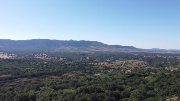 Vue aérienne par drone d'une grande forêt dense et verte à la campagne dans les collines avec une végétation verdoyante et des montagnes à Madrid, Espagne. Ciel bleu, pendant la journée. Des arbres. Tournage lent cinématographique