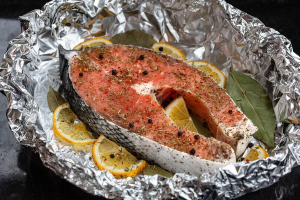 Fırında pişirmeden önce folyoda çiğ somon bifteği.