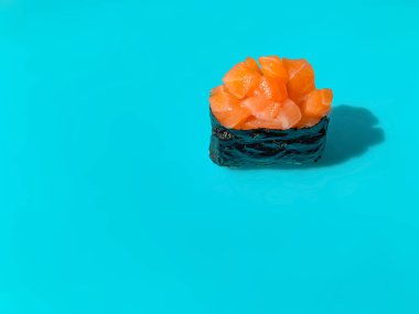 Mavi arka planda somonlu suşi gunkan.