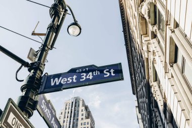 New York sokakları. Manhattan 'ın merkezi. Empire State Binası. New York caddesi tabela yönü. Kavşakta yaya istikameti işareti var. New York 'un yüksek binaları. 
