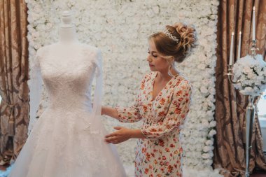 Gelin törenden önce gelinliğe bakıyor.